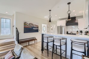 Modern chef’s kitchen with sleek finishes, stainless steel appliances, and bar seating perfect for morning coffee or après-ski bites. - Ski-In/Out Old Town Retreat • Hot Tub + Walk to Main Street | Gold Coast (Park City)