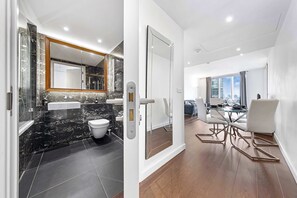 Une salle de bain moderne avec un meuble-lavabo en marbre, des toilettes et un grand miroir.
