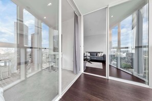 A modern apartment with large glass windows, a dining area with a glass table and chairs, and a living room with a sofa and a view of the city. - ELEVATED SHARD VIEW PANORAMIC SECRET STAY, Top Floor Penthouse, Gym and Rooftop (Greater London)