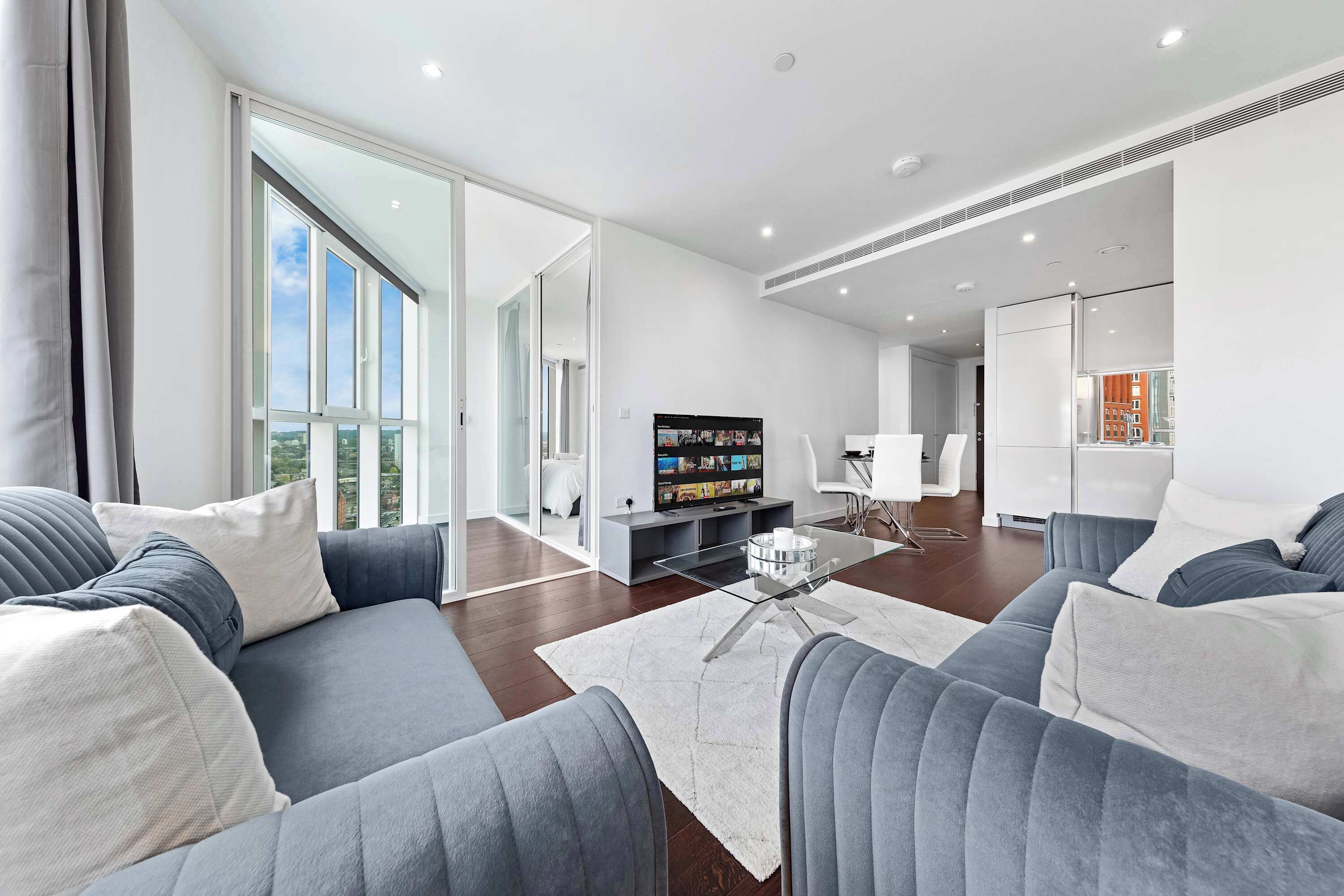 A modern living room with a sofa, a coffee table, and a television.
