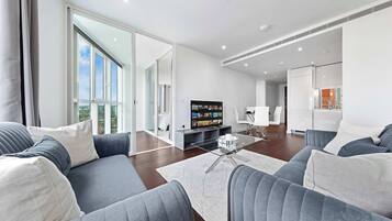 A modern living room with a sofa, a coffee table, and a television.