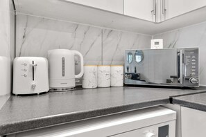 A kitchen with a coffee maker, a toaster, and a microwave.