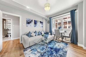 Ein modernes Wohnzimmer mit einer Couch, einem Couchtisch und Kunstwerken an der Wand.