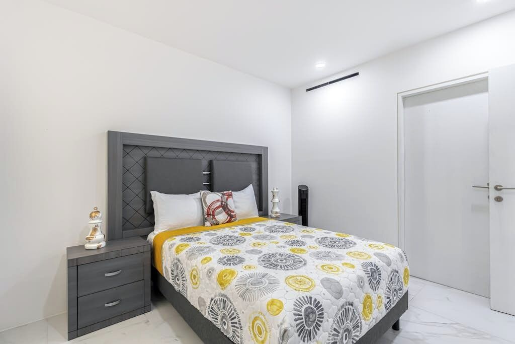 Un dormitorio moderno con una cama, mesitas de noche y una puerta.