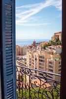 A balcony with a view of a coastal cityscape, including buildings and a church.
