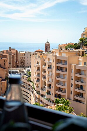 A multi-story residential building with balconies, a tower, and a view of the sea. - My Residence d'Azur (Beausoleil)
