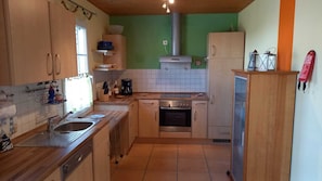 Eine kleine Küche mit Spüle, Herd, Backofen und kleinem Kühlschrank.