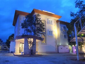 A multi-story building with a balcony, a large tree in front, and a well-lit entrance. - HOTEL CARNEVAL - Adults Only (Himeji)