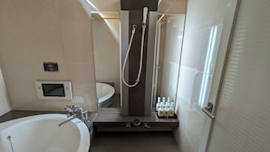 Ein modernes Badezimmer mit Badewanne, Dusche, Waschtisch mit Spiegel und Toilette.