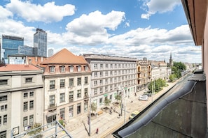 A cityscape with historic buildings, a modern skyscraper, and a clear sky. - RentPlanet - Apartamenty Dyrekcyjna (Katowice)