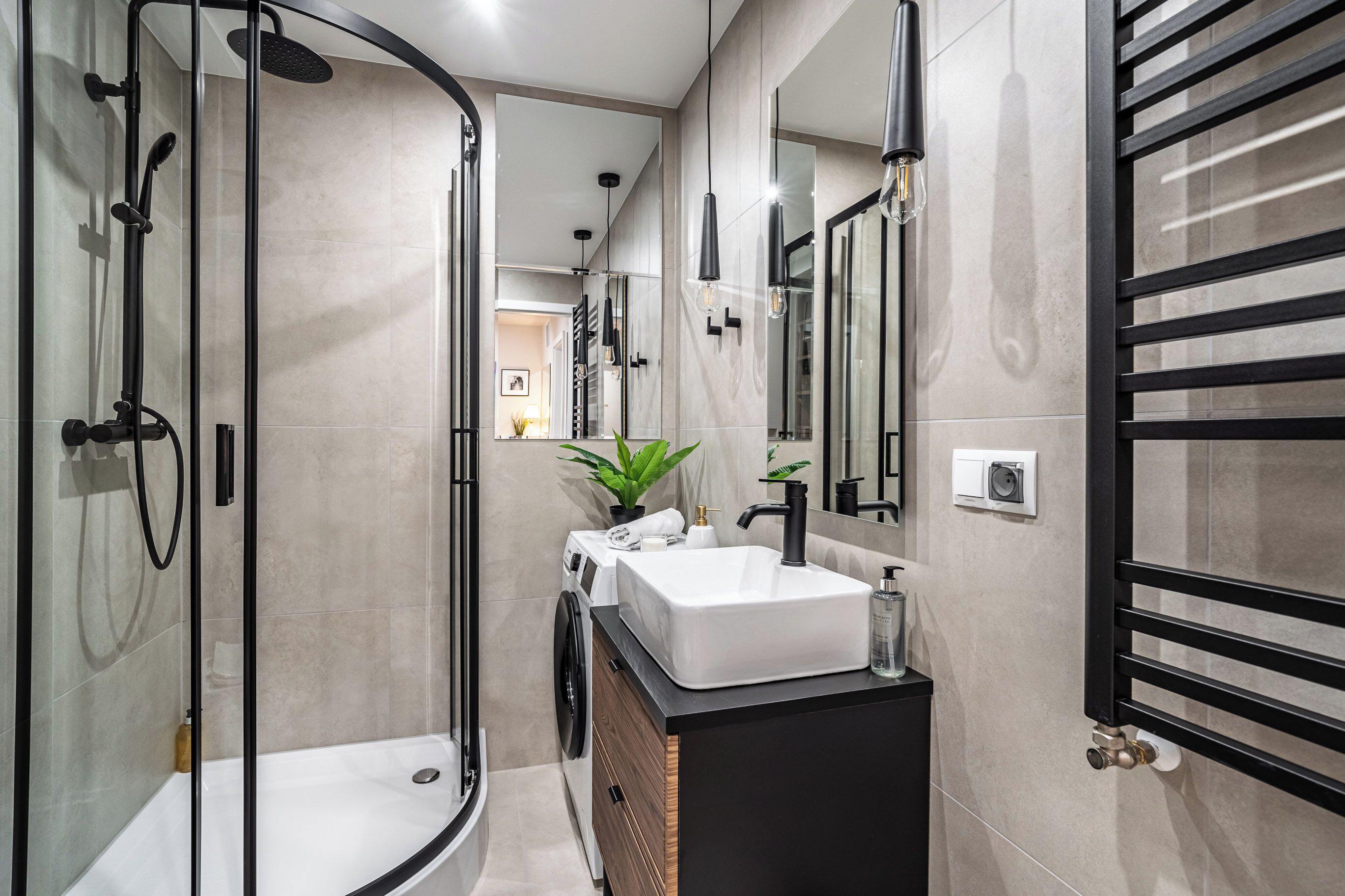 A modern bathroom with a glass-enclosed shower, a white sink, and a black vanity.