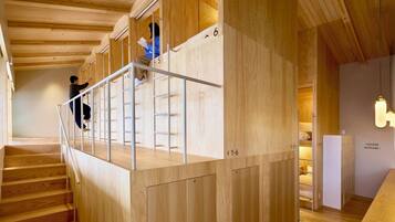 Una escalera de madera con barandilla de metal que lleva a una habitación con una exhibición de maletas.