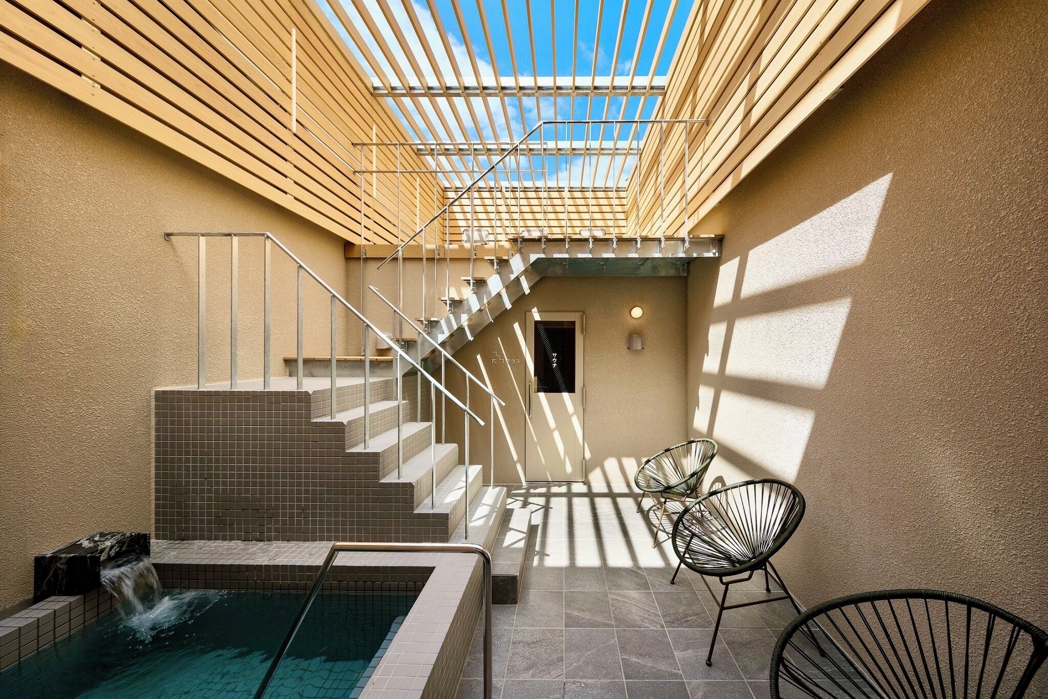 Un espace bien-être comprenant un jacuzzi, des marches carrelées et un plafond doté d’une lucarne.