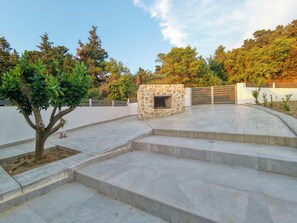 A courtyard with a stone fireplace, steps, and a gated entrance. - Aroma Zia_Mint Residence  offers a slower, more authentic way to experience Kos! (Lagoudi Zia)