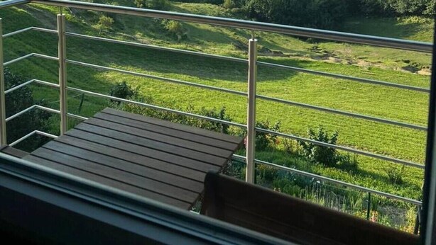 A balcony with a view of a green landscape and distant mountains. - Charming Alpine Apartment with Sauna (Kobarid)