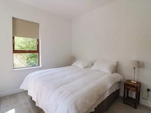 A bedroom with a bed, a window, a nightstand, and a lamp. - THE MEWS @ SUSKAR, pet friendly in Laragh, County Wicklow (Glendalough)