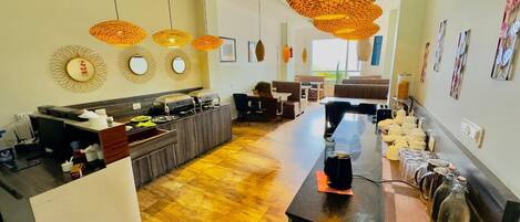 A modern kitchen with a central island, pendant lighting, and a dining area with a long table.