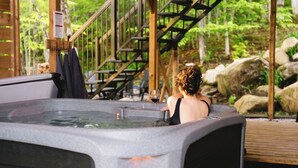 Een hottub in een natuurlijke omgeving, met houten constructies en een trap.