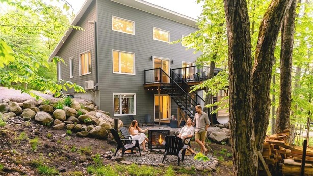 A house with a deck, outdoor seating, and a fire pit.