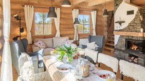 A cozy log cabin interior with a fireplace, wooden walls, and a dining area with a table set for breakfast. - Holiday Villa With Mountain Views, Koscielisko (Koscielisko)