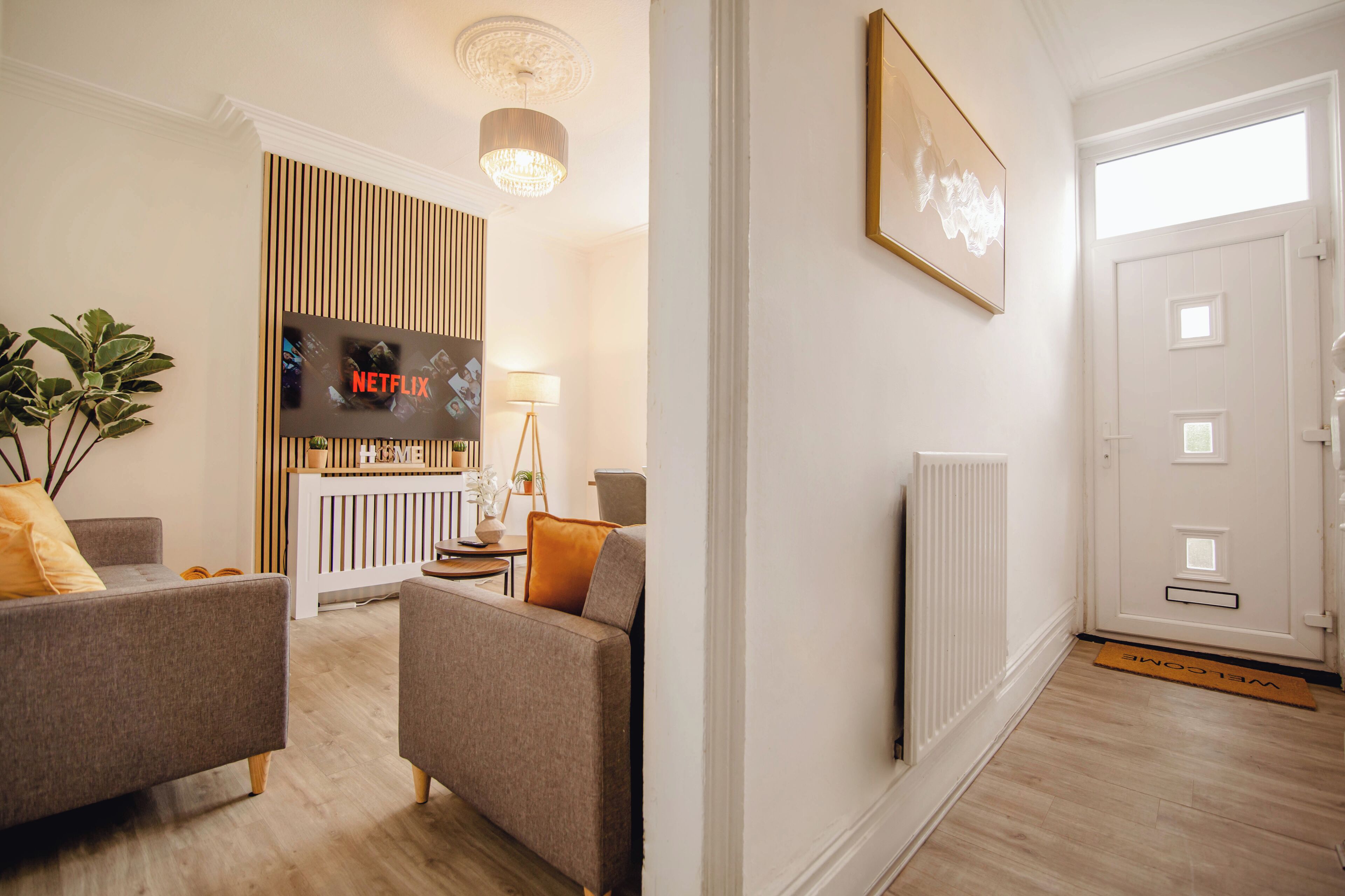 Ein Wohnzimmer mit Kamin, Fernseher und einer Tür mit Fußmatte.