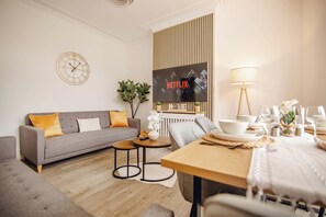 A modern living room with a sofa, coffee table, and dining area. - Group Haven 5 Bed 2 Bath | Hot Tub | Pool Table (Sheffield)