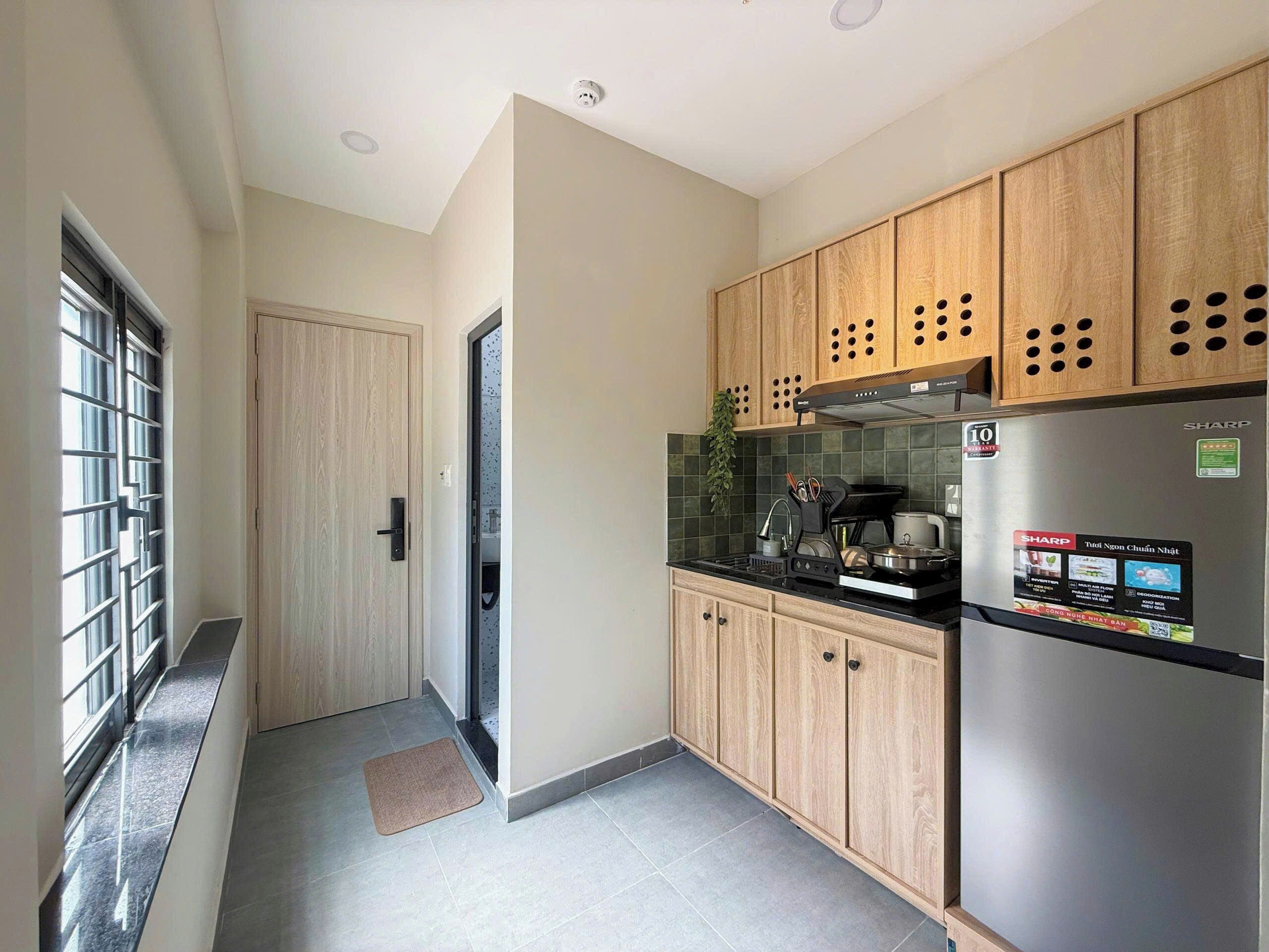 Una cocina moderna con gabinetes de madera, un refrigerador de acero inoxidable y un salpicadero de azulejos.