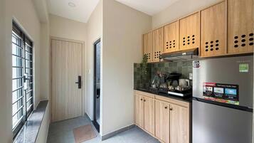 Una cocina moderna con gabinetes de madera, un refrigerador de acero inoxidable y un salpicadero de azulejos.