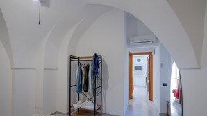 Une chambre à coucher comprenant un lit, une armoire, un miroir et un couloir menant à une autre pièce.