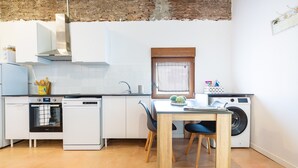 Eine kompakte Küche mit Geschirrspüler, Backofen und Waschmaschine.