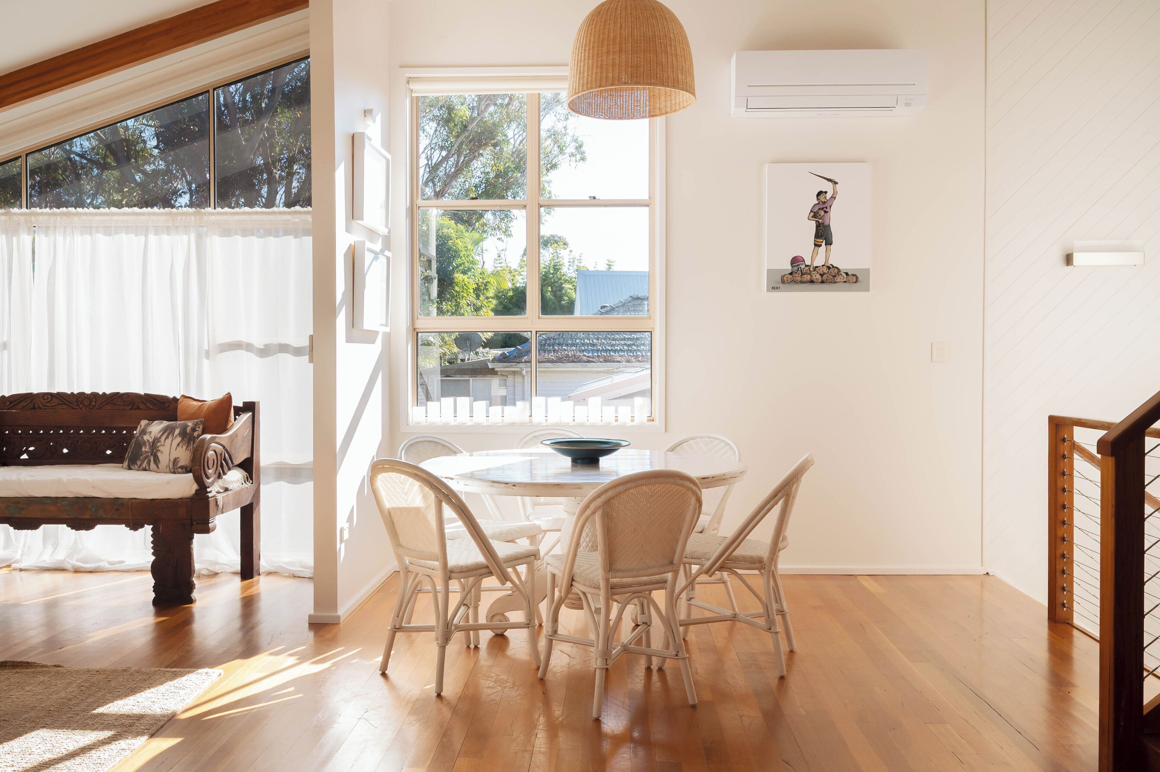 Une pièce comprenant une table à manger, des chaises, un canapé et une grande fenêtre donnant sur un beau paysage.