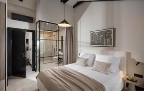 A modern bedroom with a large bed, a walk-in closet, and a shower area. - Beautiful home in Visocane with sauna (Visocane)