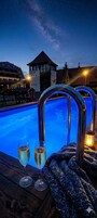Una piscina al aire libre, sombrillas, tumbonas