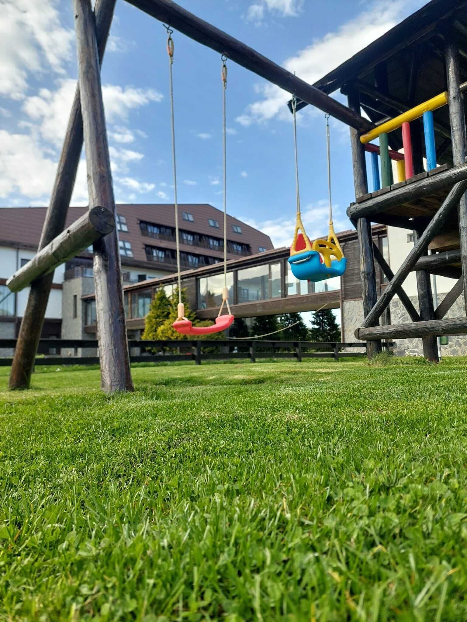 A playground with swings and a climbing structure.