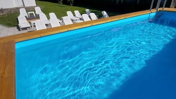 Utomhuspool, parasoller och solstolar