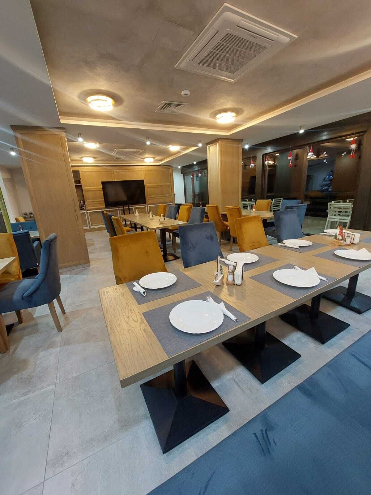 Un salón de conferencias con una larga mesa, varias sillas y una pantalla de televisión.
