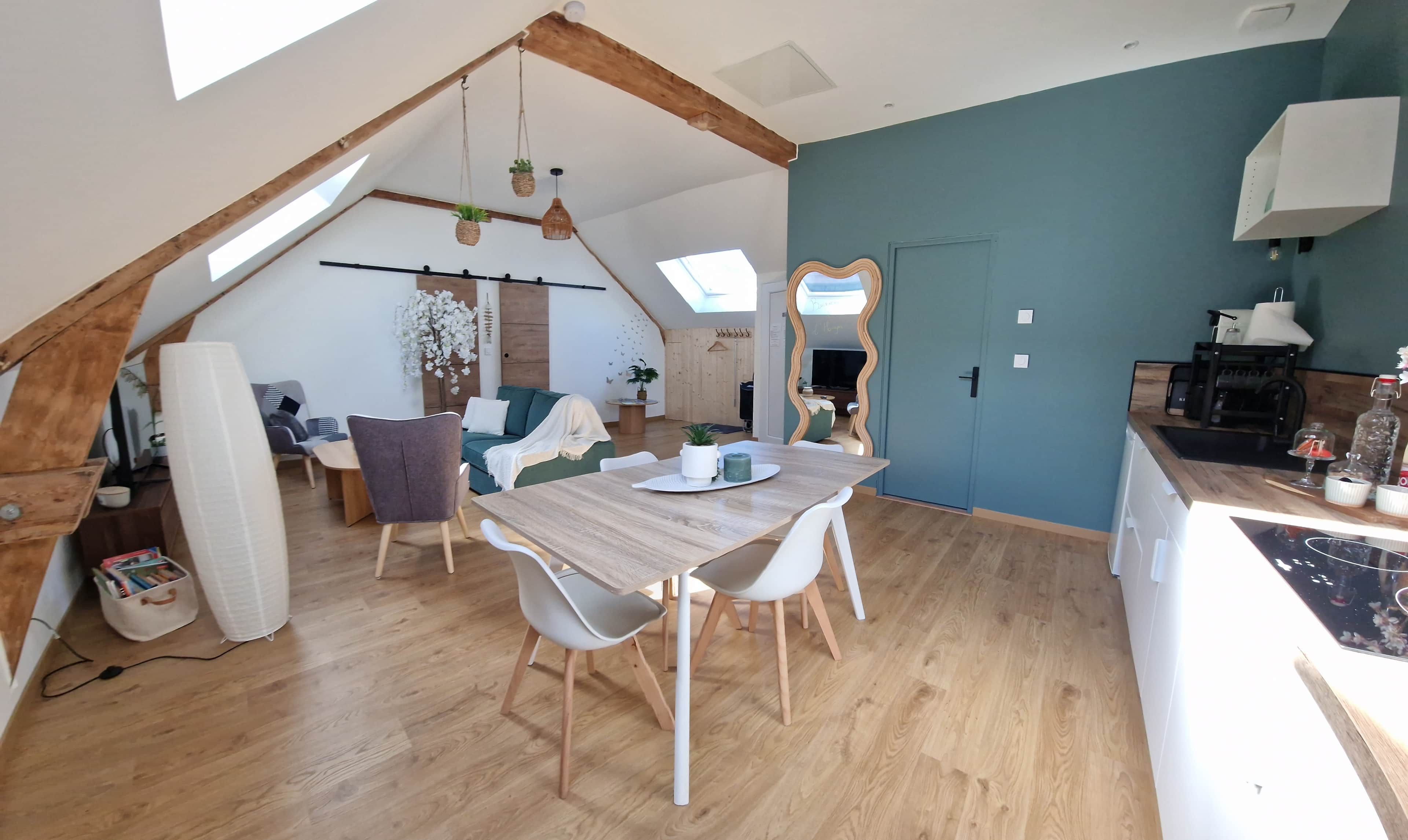 Une pièce confortable de style loft, comprenant un coin repas, une cuisine et un espace de vie.