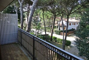 A balcony with a view of a residential area, a white fence, and trees. - Peaceful apartment with terrace in a great area (Lignano Sabbiadoro)