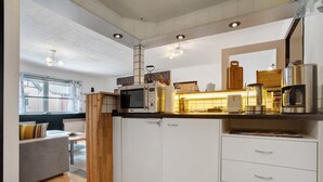 A compact kitchen with a microwave, coffee maker, and cabinets.
