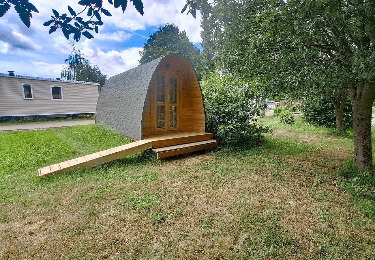 Una pequeña estructura de madera con techo inclinado, una puerta y un porche pequeño.