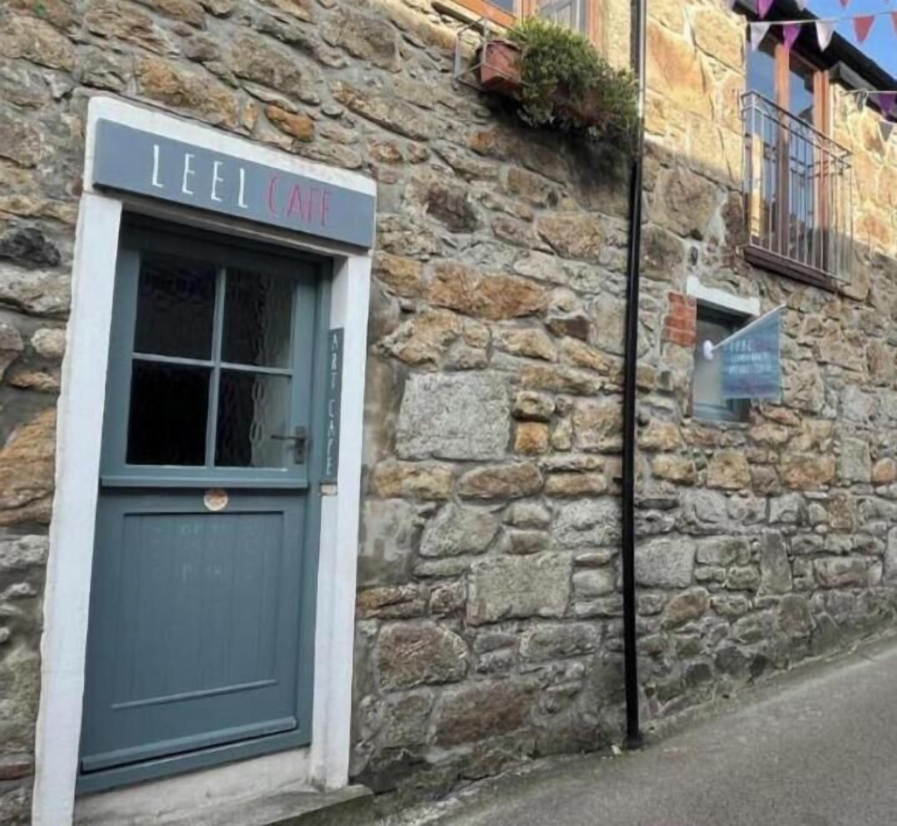A stone building with a sign reading 'LEEL CAFE' above a door.