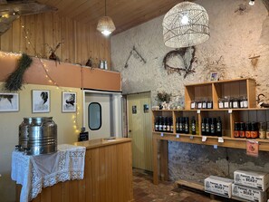 A rustic interior with wooden walls, a reception desk, and shelves stocked with bottles. - Bed and Breakfast 'Chambre 1' (Allouis)
