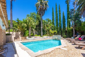 A swimming pool surrounded by lounge chairs and palm trees. - Garden-Level Villa & Independent Guest House 'Strelitzia' Near the Beach (Sainte-Maxime)