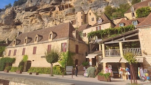 A stone building with a balcony and a sign for a restaurant.