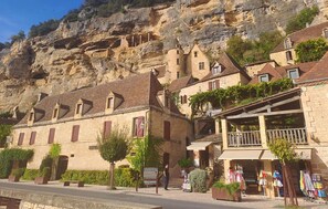 Ein Steinhaus mit Balkon und Schild für ein Restaurant.