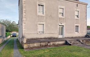 Ein zweistöckiges Gebäude mit einer zentralen Tür und Fenstern in jeder Etage.