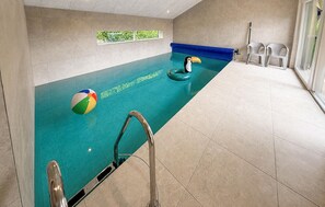 Ein Swimmingpool mit einer blauen Wasserspalt, einem Strandball und einer Schnorchelmaske.