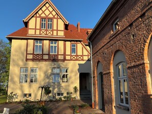 A two-story building with a gabled roof, multiple windows, and a brick facade. - Stylish Art Nouveau apartment in an idyllic rural setting (Zerbst/Anhalt)
