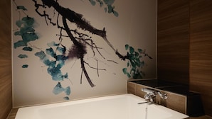 A bathroom with a white bathtub, a modern faucet, and a wall with a blue and black abstract design. - HOTEL TIGER & DRAGON - Adults Only (Gifu)