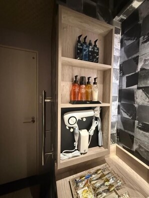 A wooden cabinet with shelves containing toiletries and a hairdryer. - HOTEL TIGER & DRAGON - Adults Only (Gifu)